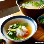 Home 23 한국과 일본의 조미 원칙 차이점 - Photorealistic Vietnamese home kitchen at golden afternoon, a cook preparing a vibrant bowl of pho b...